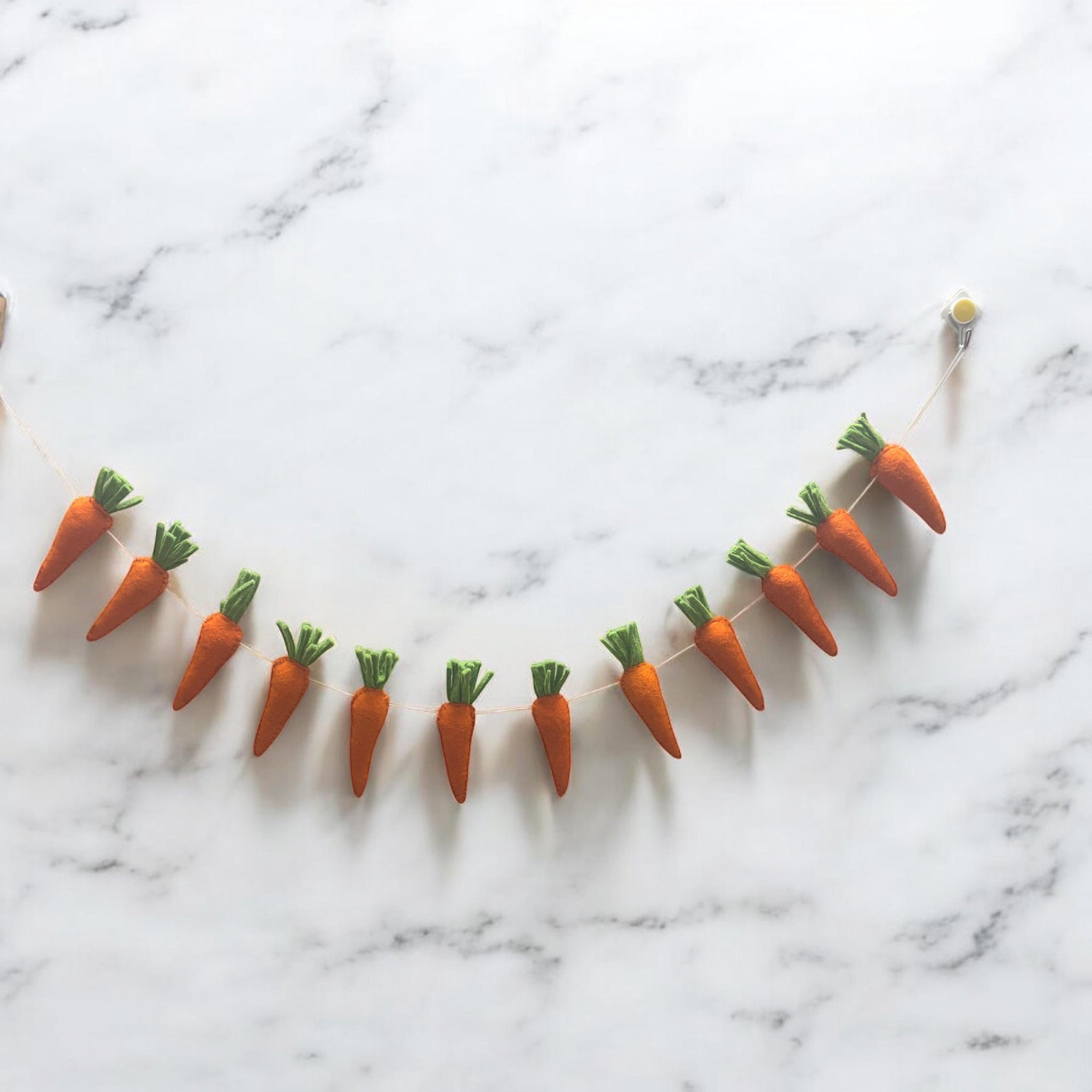 Decorative string of small carrots on a marble surface