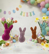 Decorative Easter scene with colorful bunnies, balloons, and flowers on a white background.