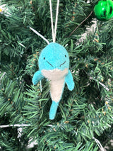 Blue narwhal ornament hanging on a Christmas tree