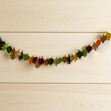 Colorful leaf-shaped garland on a wooden surface