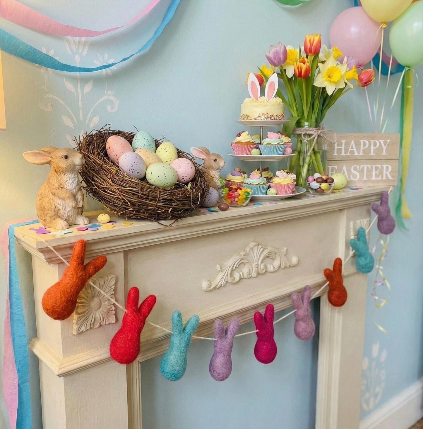 Easter-themed decor with eggs, bunny figurines, and colorful balloons on a mantelpiece.