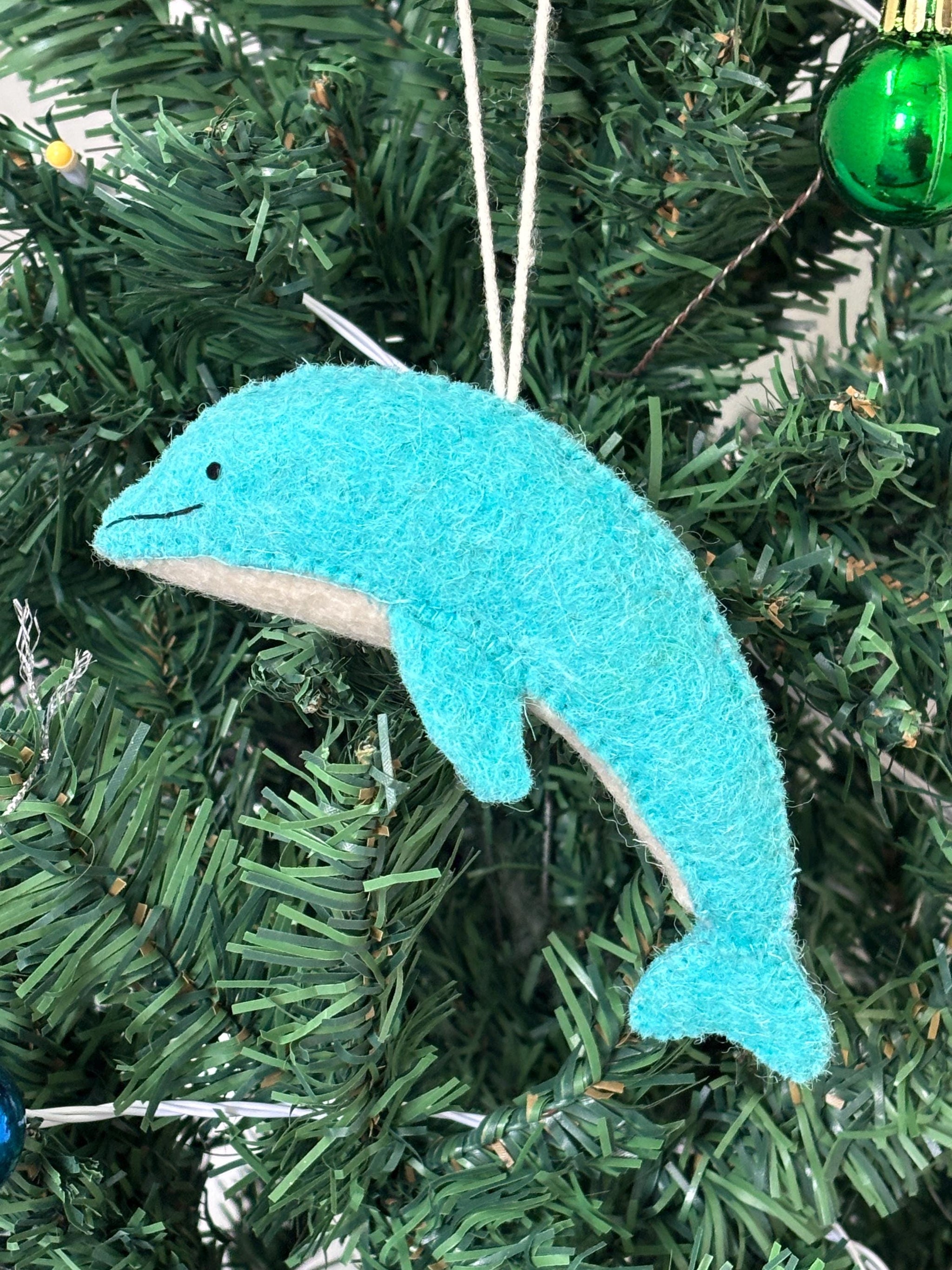 Blue dolphin ornament hanging on a Christmas tree