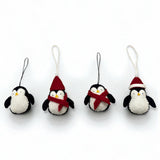 Four penguin ornaments with scarves and hats on a white background