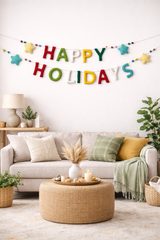 Living room with 'Happy Holidays' banner, beige sofa, and decorative items.