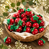 Basket of red felt strawberries with white polka dots on a wooden surface with flowers.