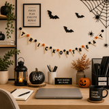 Halloween-themed office desk with decorations, plants, and a laptop.