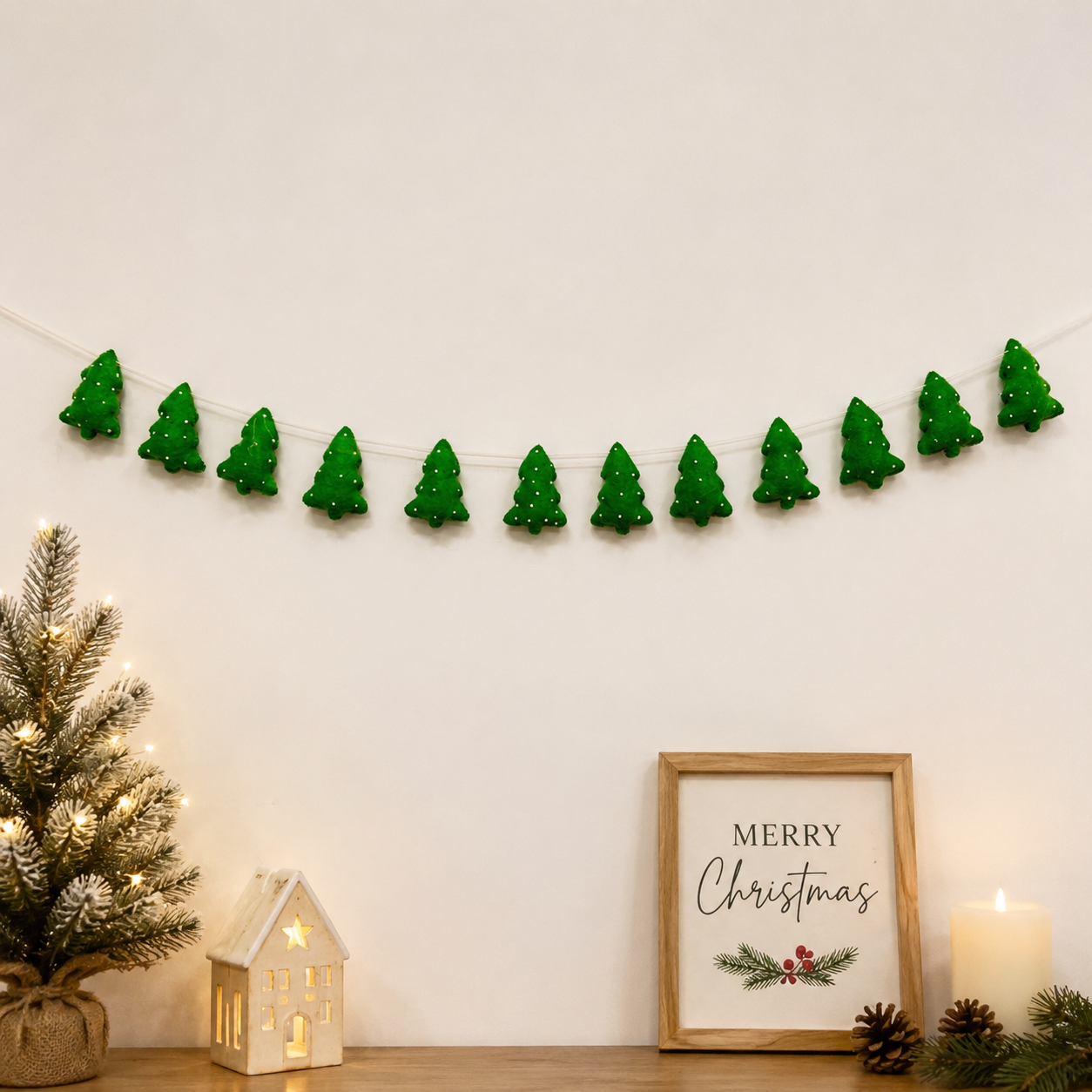 Decorative green Christmas tree garland on a wall with a 'Merry Christmas' sign and small tree.