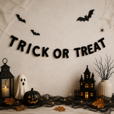 Halloween-themed decorations with 'TRICK OR TREAT' banner, pumpkins, lanterns, and bats on a neutral background.