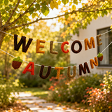 Decorative banner with 'Welcome Autumn' text hanging outdoors in a garden.