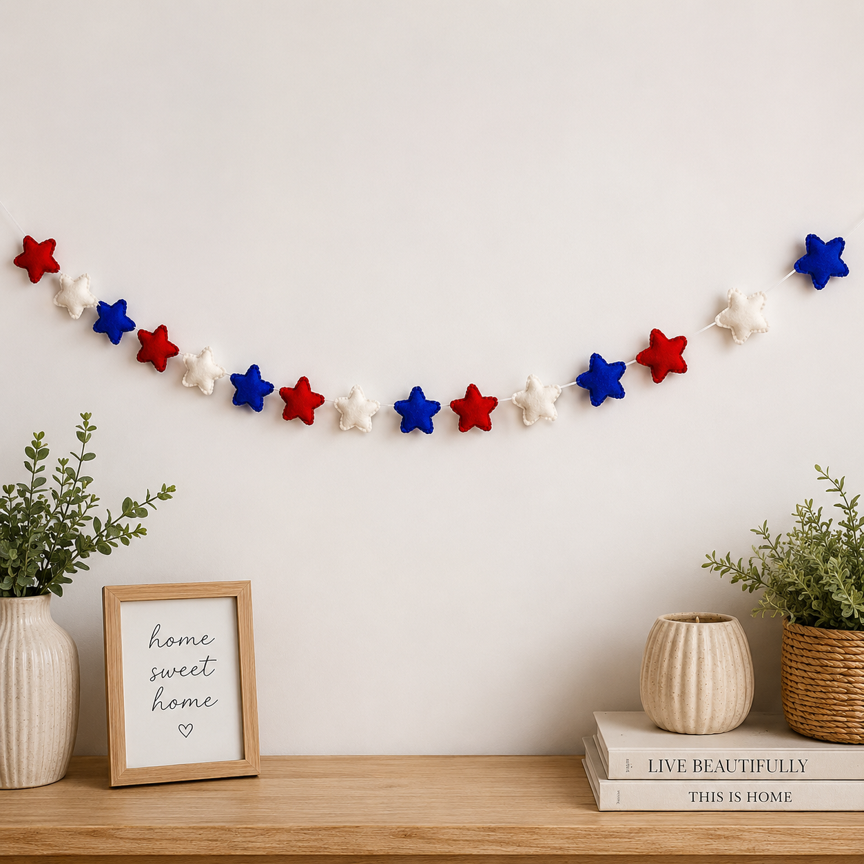 Decorative star garland on a wall above a wooden shelf with plants and a framed sign.