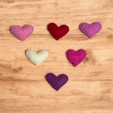 Colorful heart-shaped objects on a wooden surface