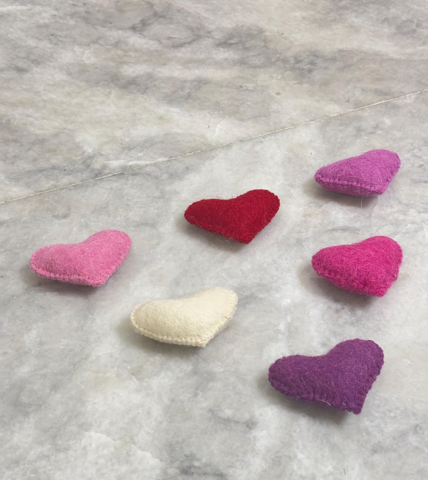 Colorful heart-shaped objects on a marble surface