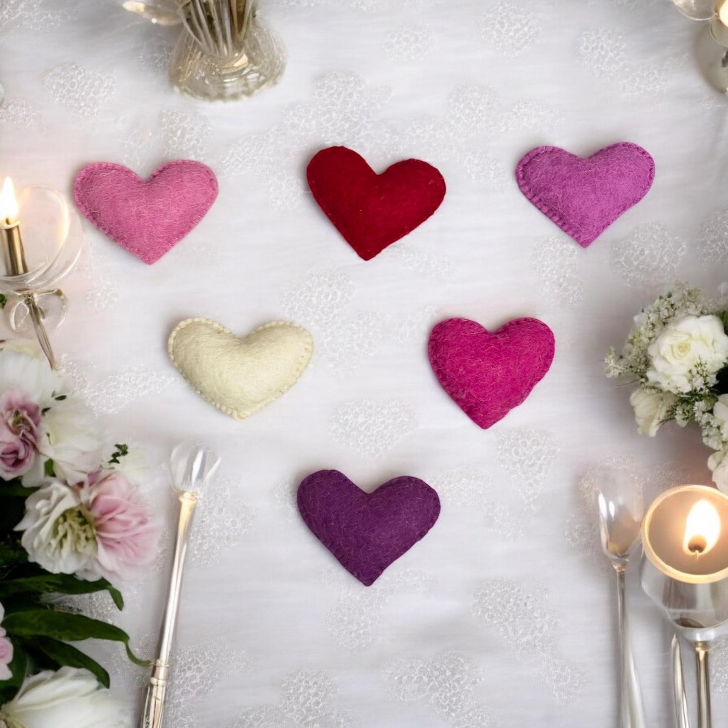 Colorful heart-shaped decorations on a table with candles and flowers