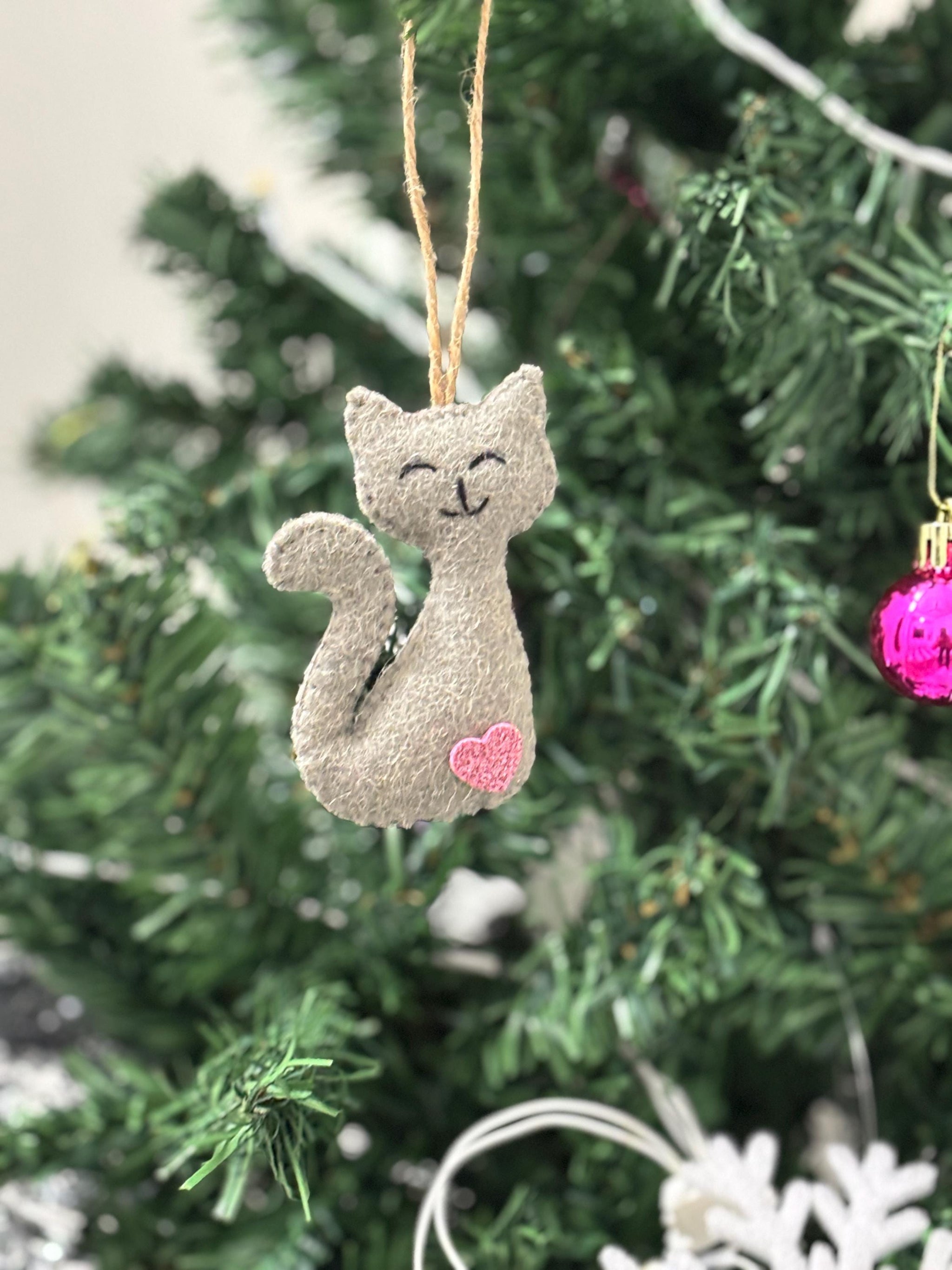 Gray cat-shaped ornament hanging on a Christmas tree