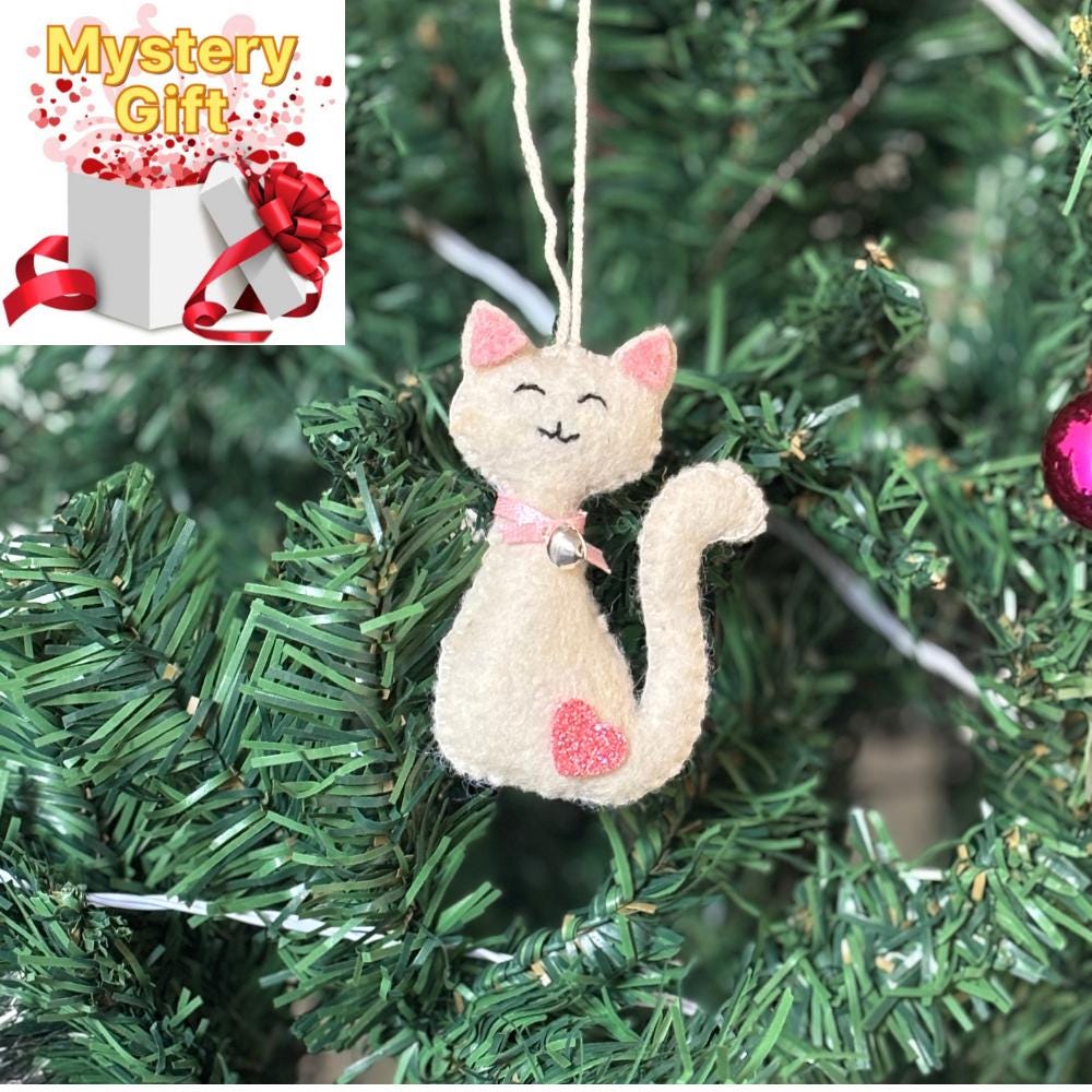 Cat-shaped Christmas ornament hanging on a tree with a 'Mystery Gift' graphic.