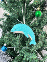 Blue dolphin ornament on a Christmas tree with other decorations.