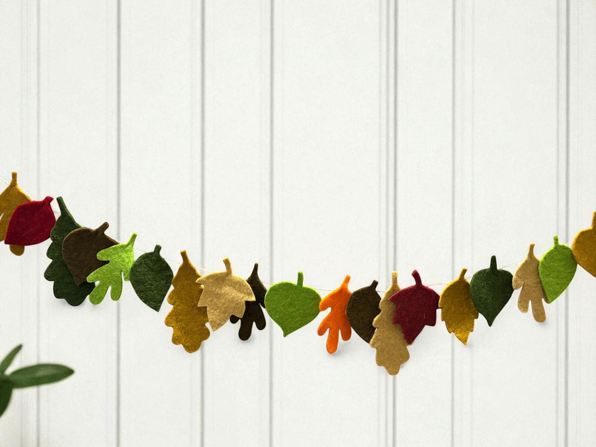Decorative leaf garland on a white wooden background