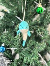 Teal plush ice cream cone ornament hanging on a Christmas tree with other ornaments.