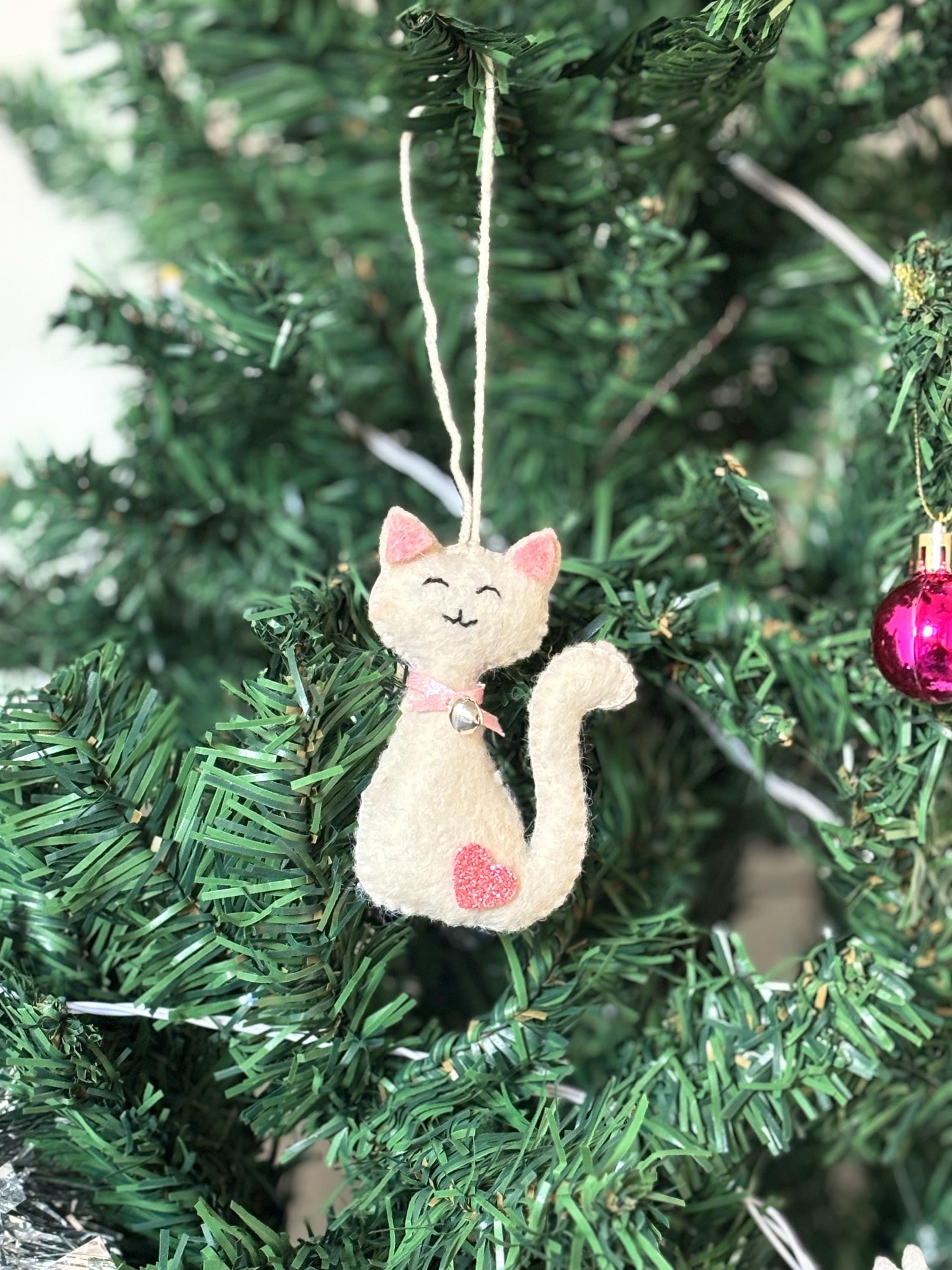 Cat-shaped Christmas ornament hanging on a tree