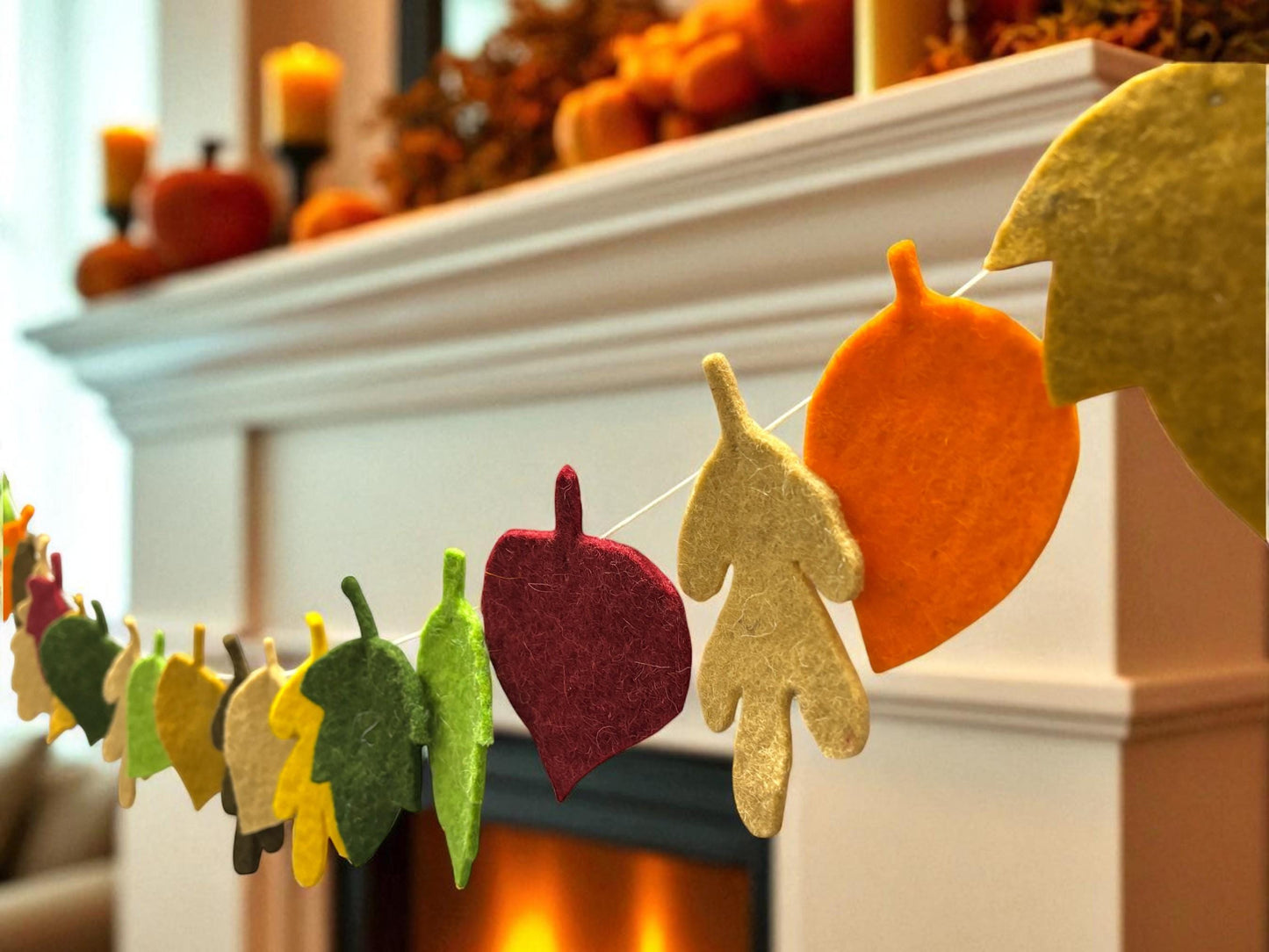 Decorative leaf banner in front of a fireplace with autumn decorations.