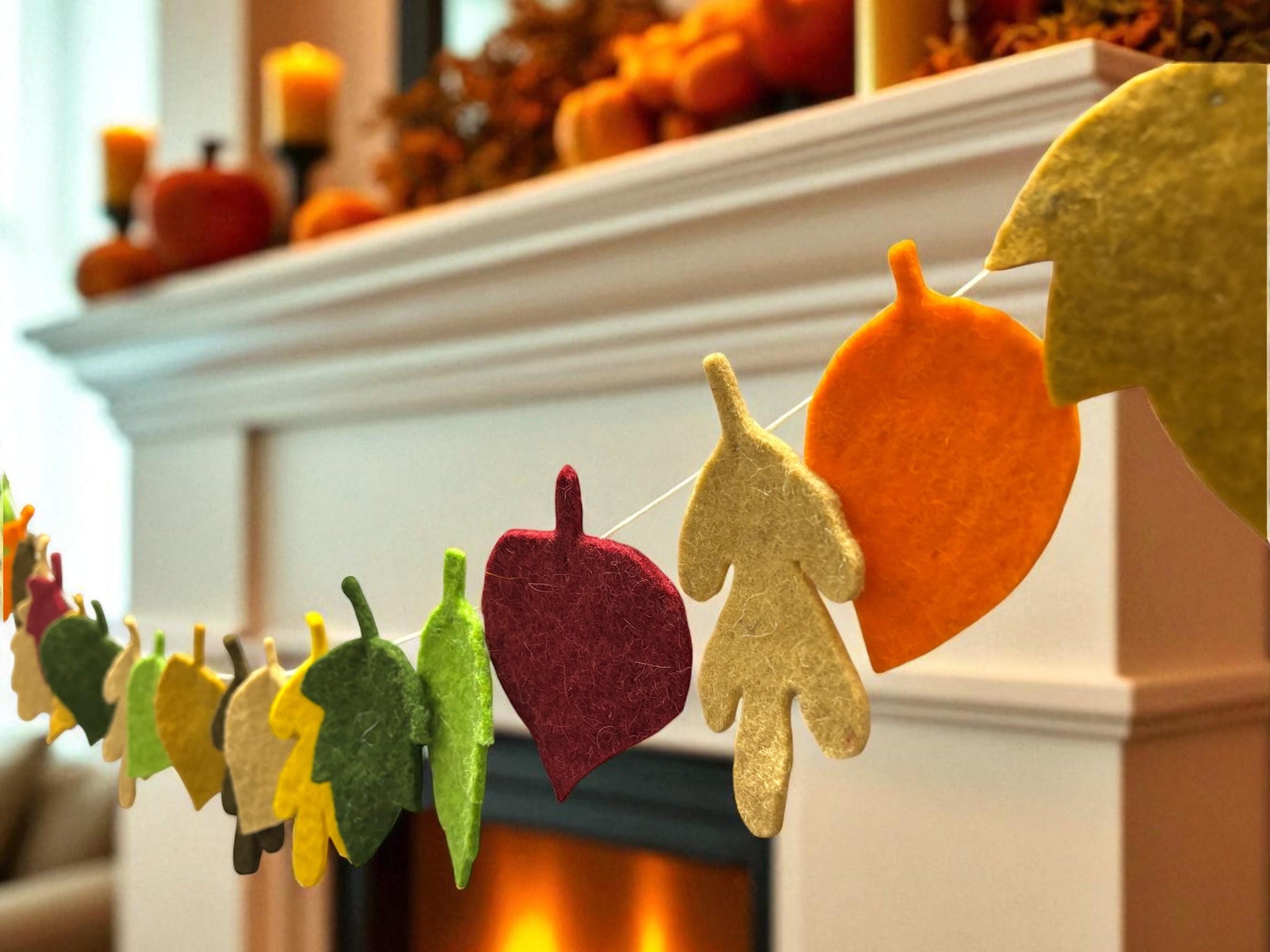 Decorative leaf banner in front of a fireplace with autumn decorations.