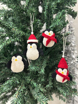 Penguin Christmas ornaments on a tree with a snowy background