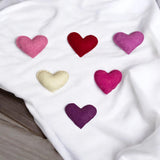 Colorful heart-shaped cushions on a white blanket